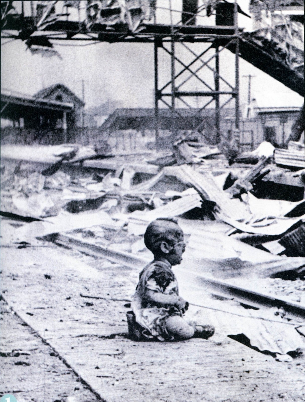 难民聚集的上海南火车站遭到日军轰炸，大量平民伤亡。图为小男孩坐在地上嚎啕大哭，浑身污泥，恐惧无助。（摄影：王小亭）.jpg