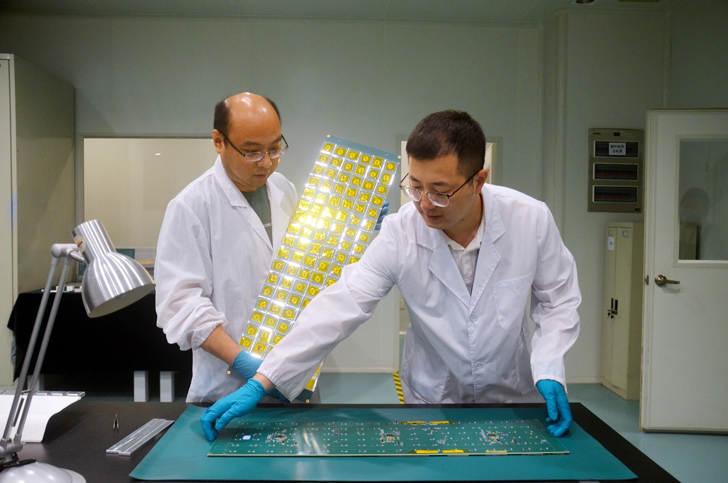 【先进辐射探测晶体与器件课题组工程师宋晓健（左）和李翔（右）处于芯片材料的操作状态】（三盅摄）.JPG